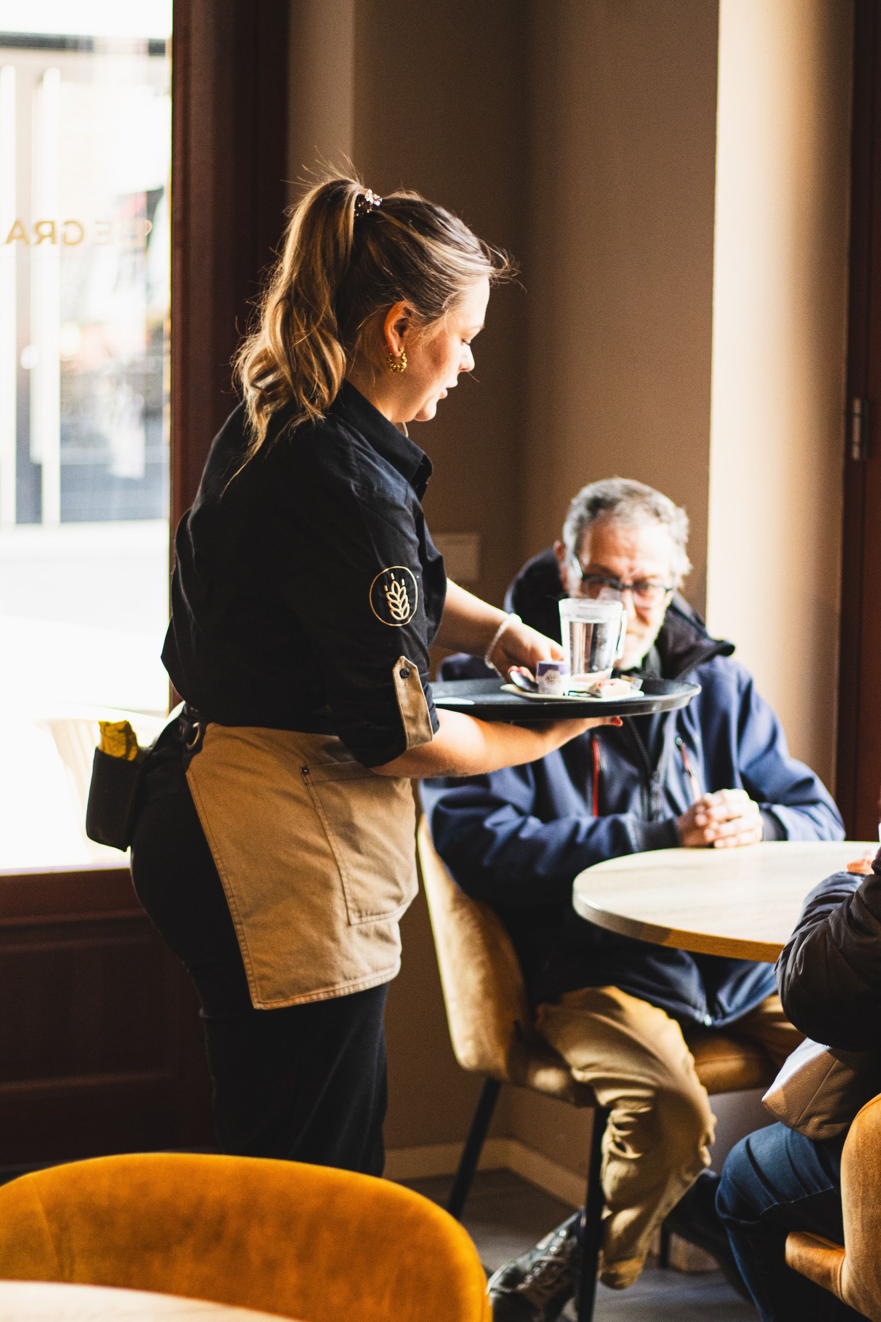 Bediening serveert gasten aan tafel in het grand café van De Graanbeurs in Venlo